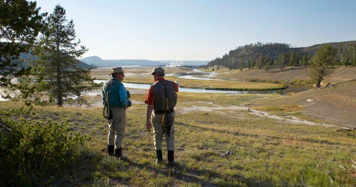Two men looking at a river in Yellowstone National Park. (Representative Cover Image Source: Getty Images | Stewart Sutton)