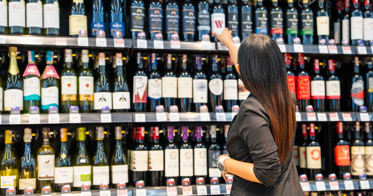 A woman is purchasing wine at a retail store. (Representative Cover Image Source: Getty Images | Witthaya Prasongsin)