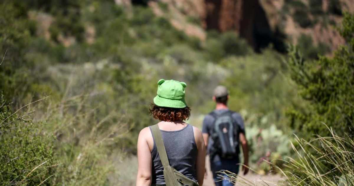 Visitors walking through towering mountain terrain in Big Bend National Park region (Representative Cover Image Source: Getty Images | Jennifer M Ramos)