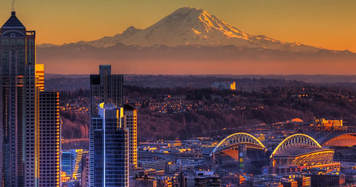 Mount Rainier towering majestically under orange skies viewed from the city (Representative Cover Image Source: Getty Images | Alaska Photography)