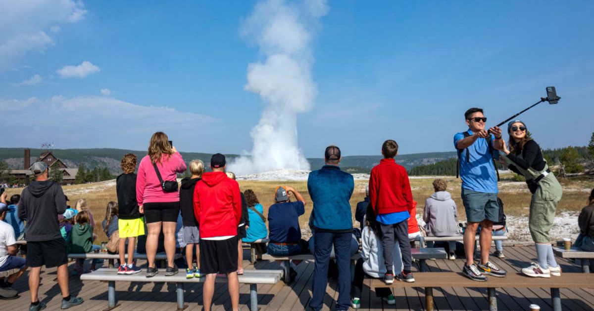 Visitors watching a geyser at Yellowstone National Park. (Representative Cover Image Source: Getty Images | Jonathan Newton)