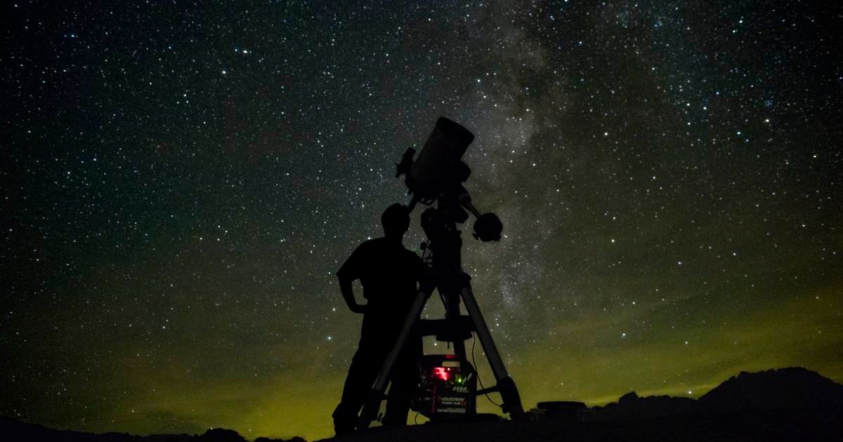 A person observing starry objects in space through a telescope (Representative Cover Image Source: Getty Images | Tony Rowell)