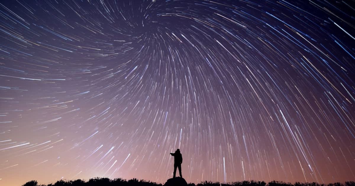 Silhouette of a person standing under a sky filled with shooting stars (Representative Cover Image Source: Getty Images | Eyem Mobile GMPH)