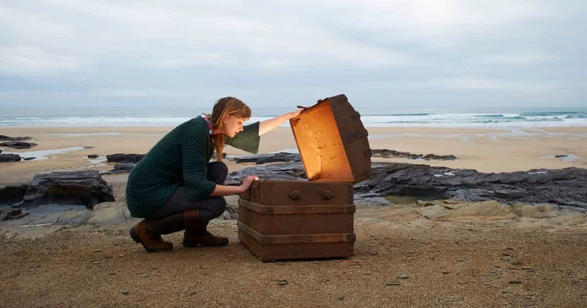 A woman looks inside a treasure chest (Representative Cover Image Source: Getty Images | Dougal Waters)