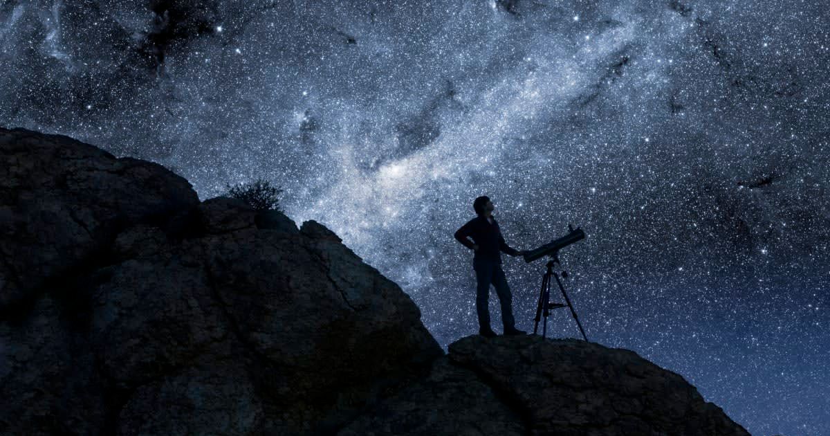 Man standing on a desert dune gazing at stars in the sky (Representative Cover Image Source: Getty Images | Bryan Allen)