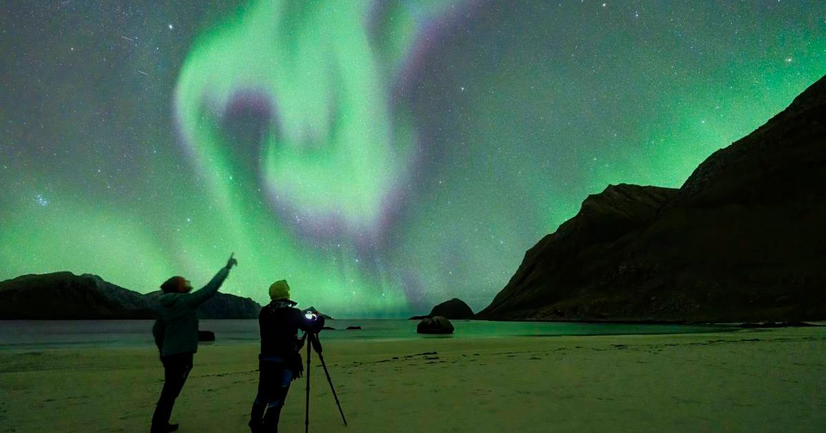 Two people looking at auroras in the sky. (Representative Cover Image Source: Getty Images | Roberto Moiola)