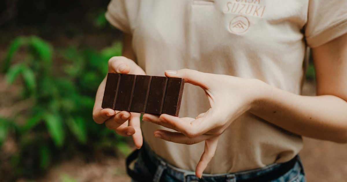Woman holding a bar of dark chocolate (Representative Cover Image Source: Unsplash | Kawe Rodriguez)